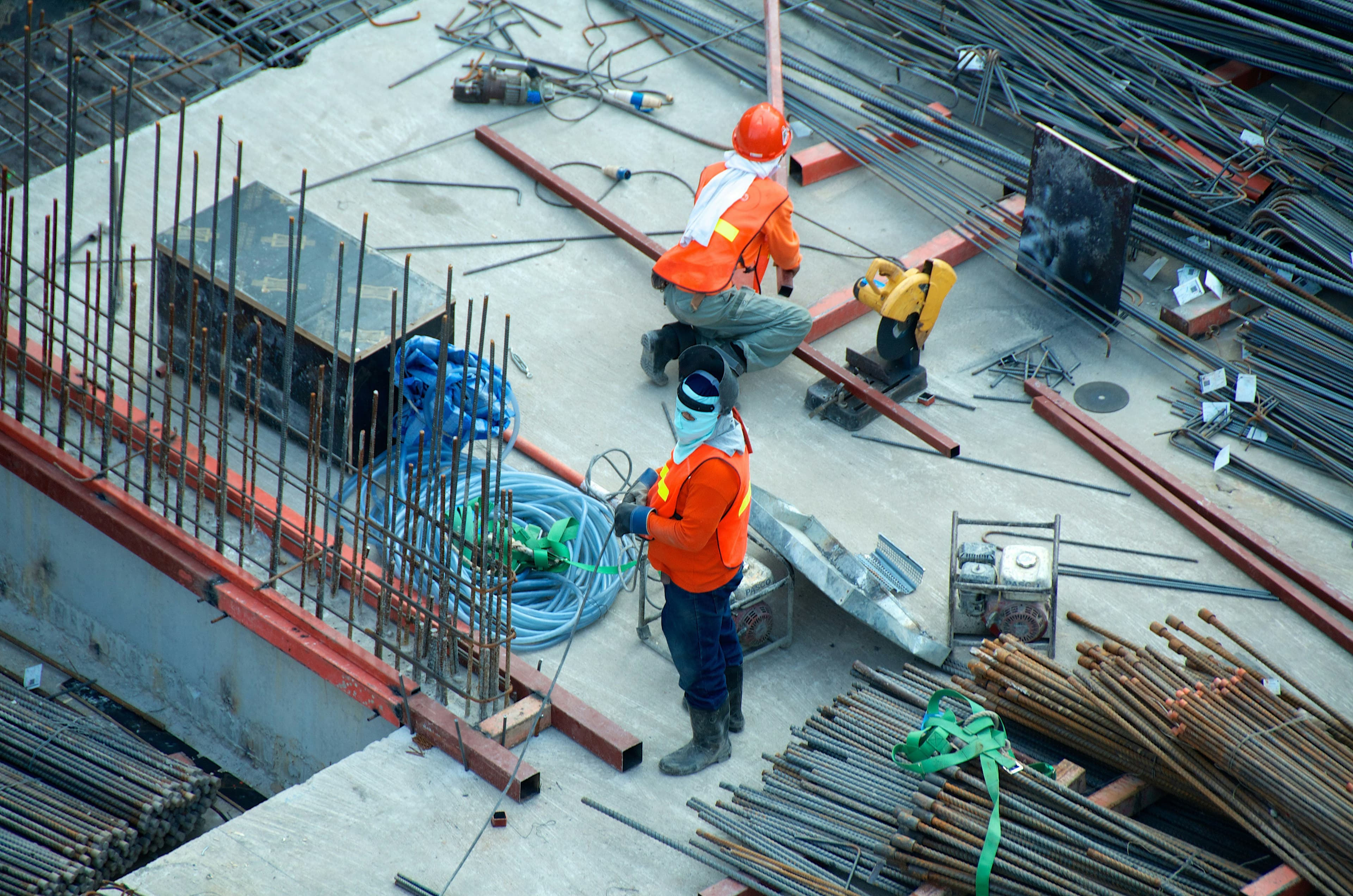 Obra en estructura, con ferralla y tres operarios con casco.